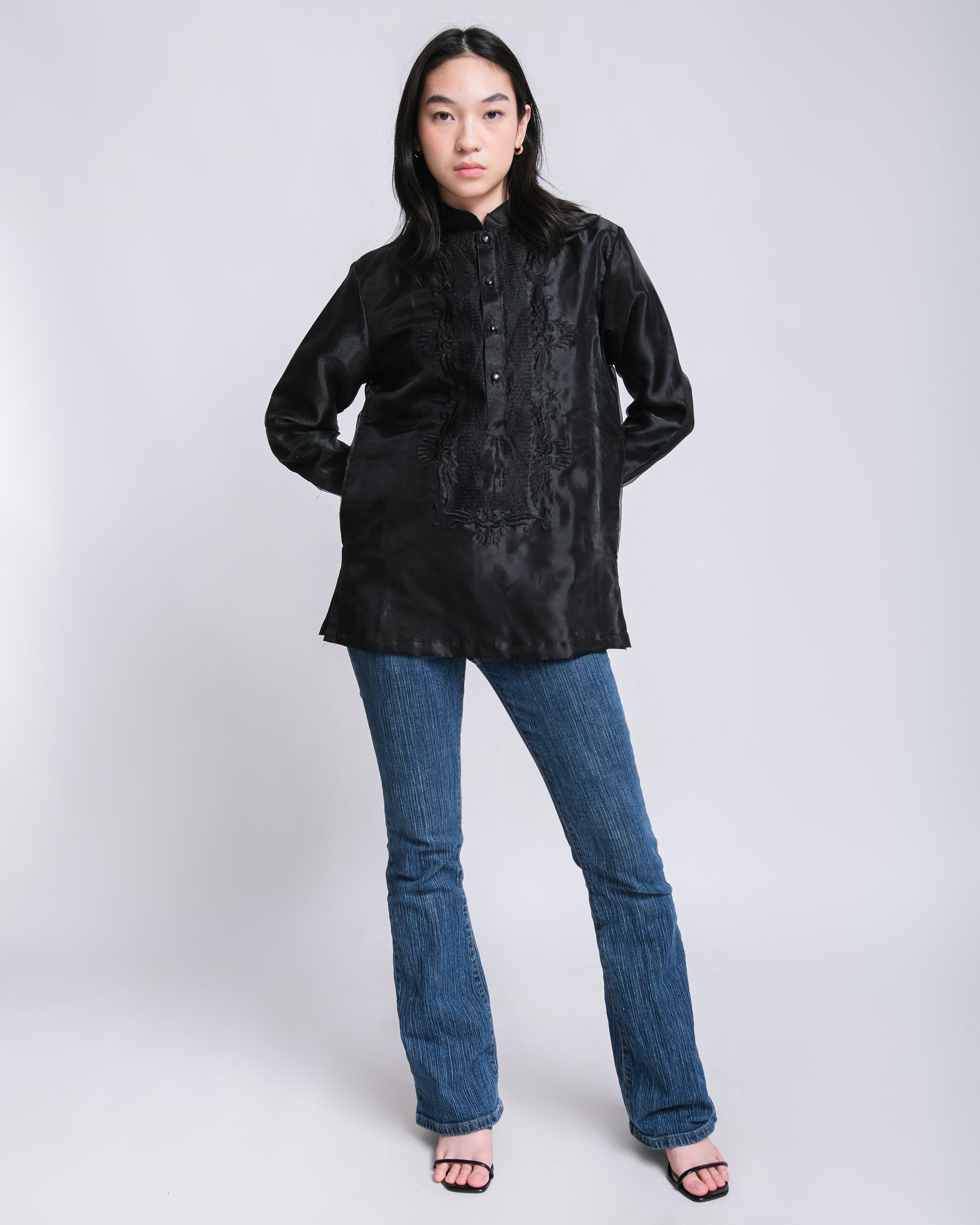 Confident woman wears Enrique modern barong with black floral embroidery, effortlessly paired with jeans