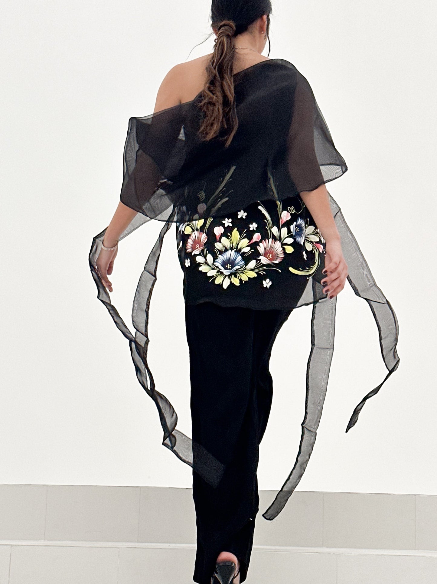 Woman wears Tadhana modern Filipiniana waistcoat, effortlessly paired with an elegant tube top and tailored pants.