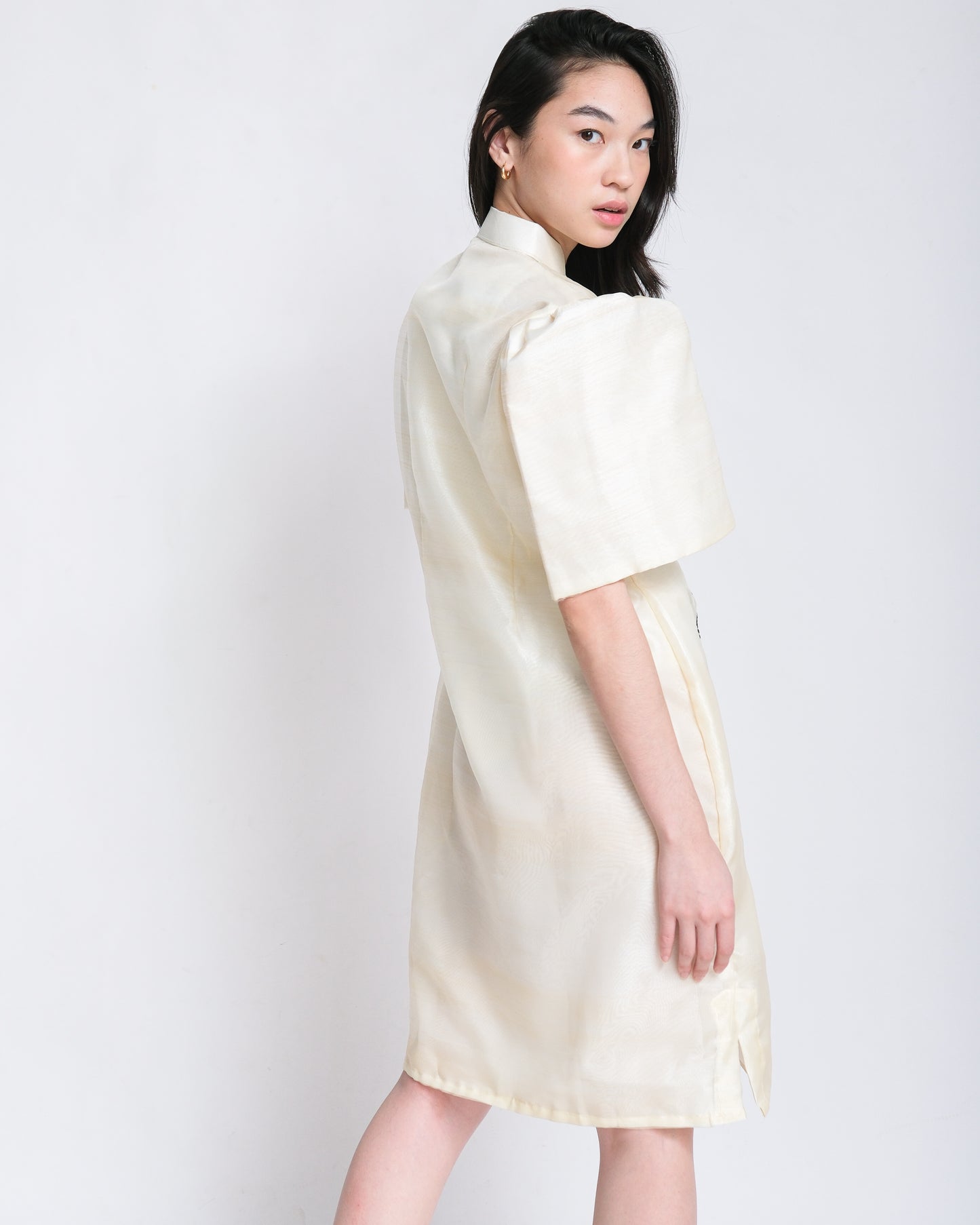 Woman effortlessly wears Olivia Filipiniana dress with cream embroidery and Maria Clara sleeves, exuding timeless elegance