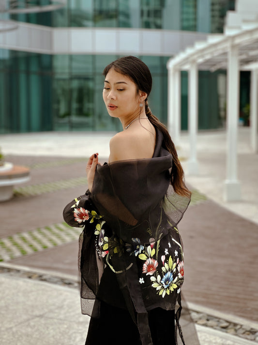 Woman wears Tadhana modern Filipiniana waistcoat, effortlessly paired with an elegant tube top and tailored pants.