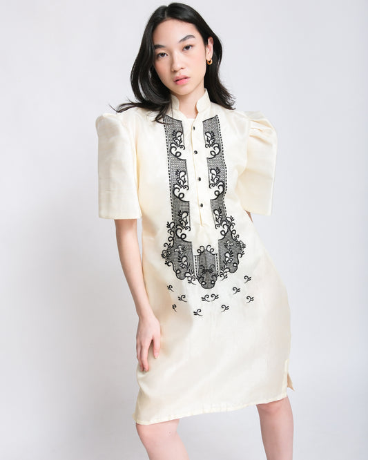 Woman effortlessly wears the Kiara Filipiniana dress, crafted from light organza with elegant black embroidery